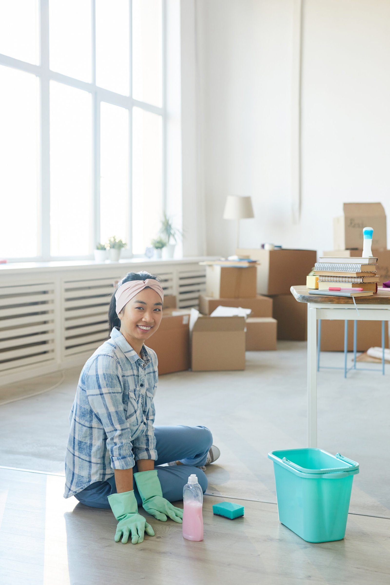 A cleaner scrubbing kitchen appliances and countertops before move-in.